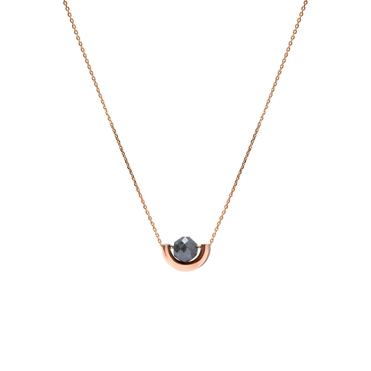 A delicate rose gold chain necklace featuring a small, polished gold crescent-shaped setting holding a round, dark gray diamond, presented on a solid white background.