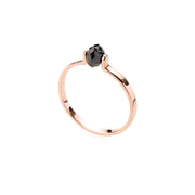 Gold ring with a black faceted diamond on a white background