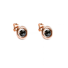 A pair of rose gold stud earrings with a central faceted black diamond, set against a plain white background.