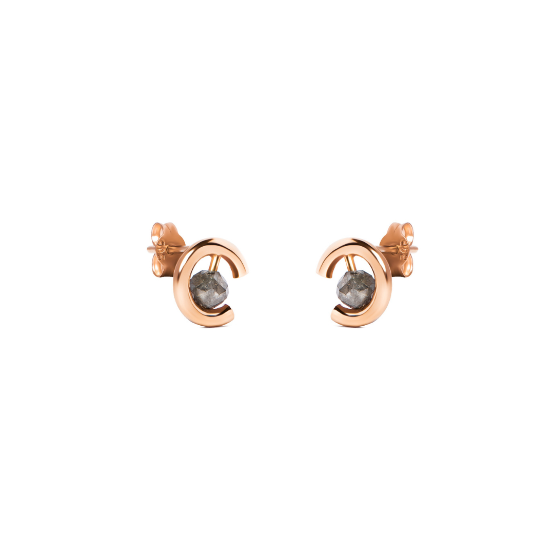A pair of gold crescent-shaped stud earrings with round grey diamonds, shown on a plain white background.
