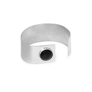 A minimalist silver metal cuff bracelet with a square plate on one side featuring a circular black amber, shown on a plain white background.