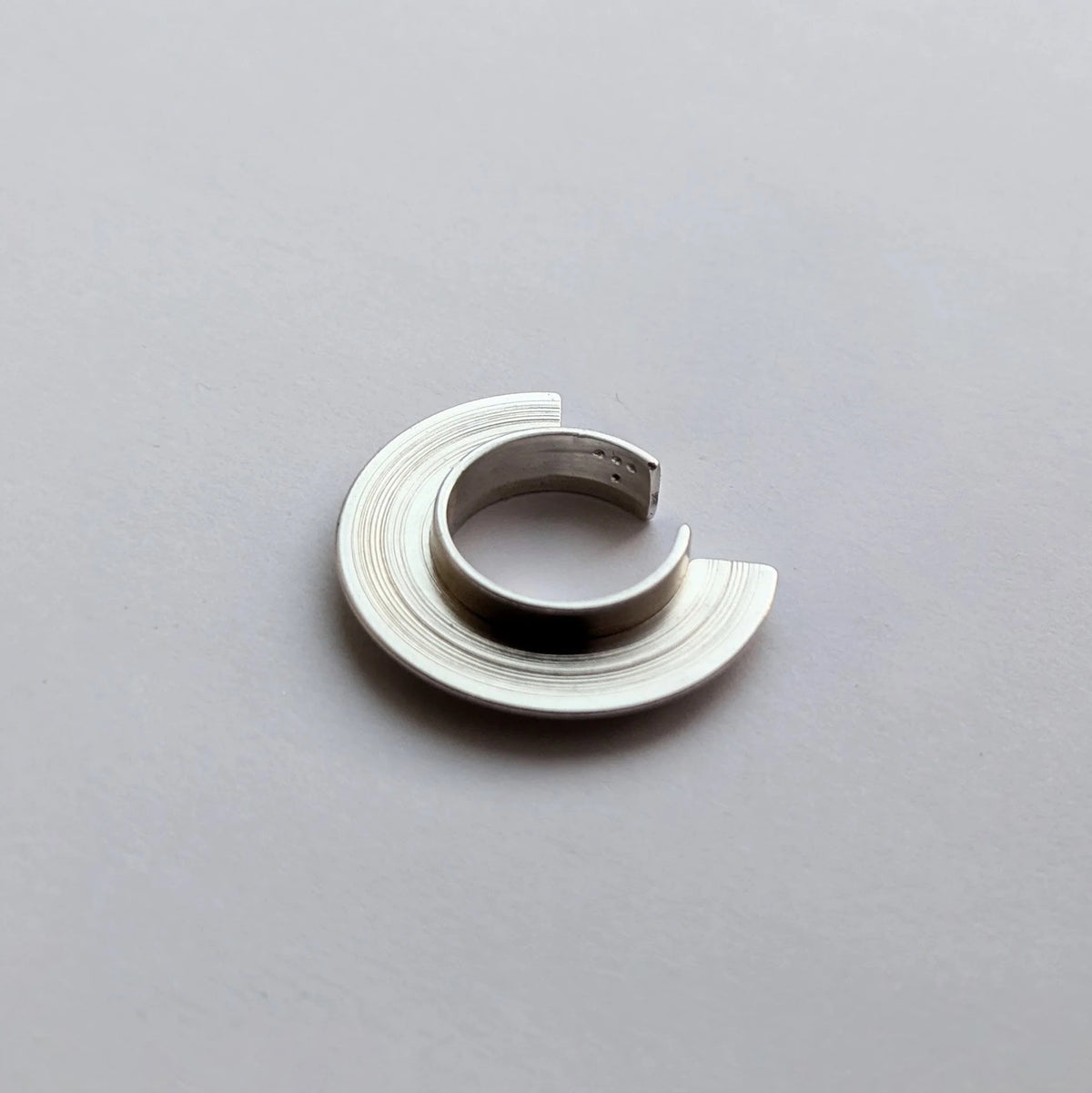 Silver ear cuff on a gray background