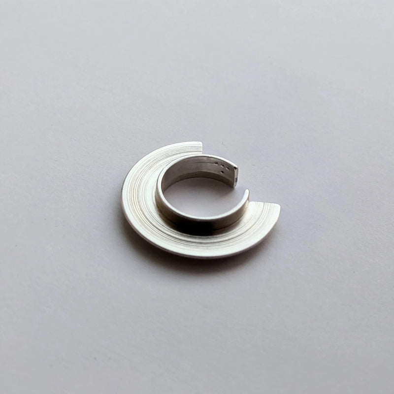 Silver ear cuff on a gray background