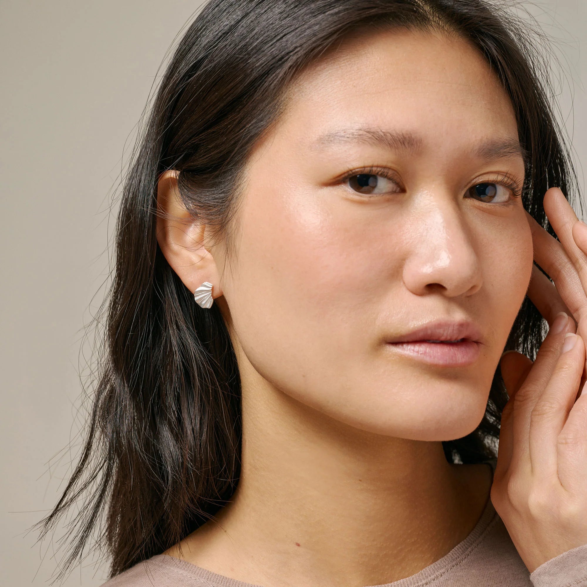 Woman wearing earrings with a neutral background