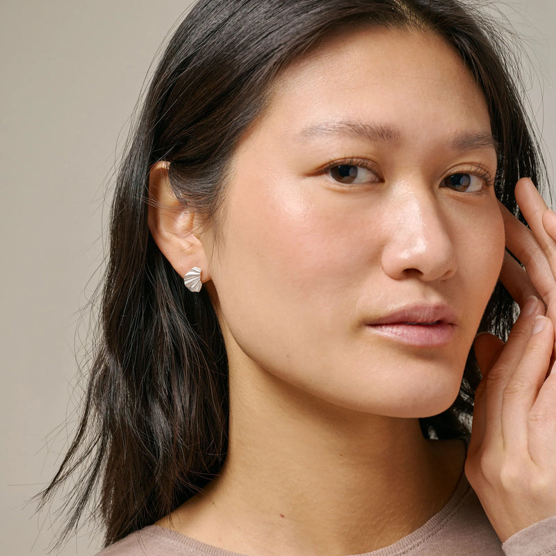 Woman wearing earrings with a neutral background