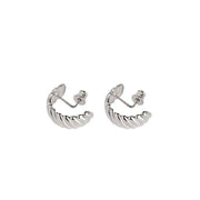 A pair of silver huggie hoop earrings featuring a twisted design, shown on a plain white background.