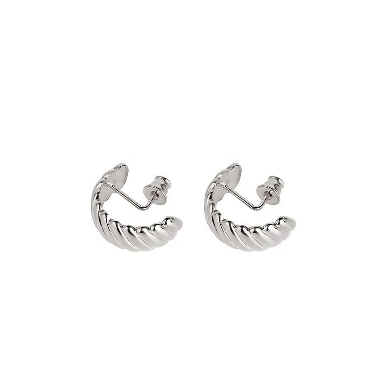 A pair of silver huggie hoop earrings featuring a twisted design, shown on a plain white background.