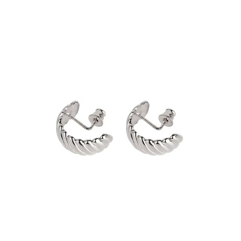 A pair of silver huggie hoop earrings featuring a twisted design, shown on a plain white background.