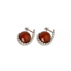 Pair of silver earrings with a sculptural silhouette, featuring polished amber stones framed by a twisted design.