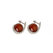 Pair of silver earrings with a sculptural silhouette, featuring polished amber stones framed by a twisted design.