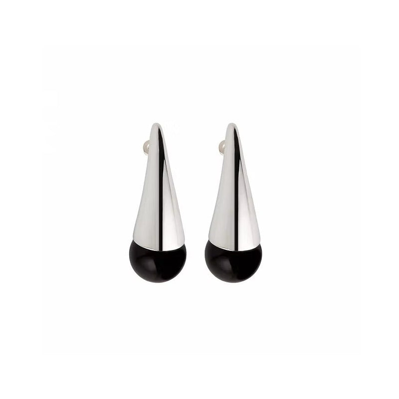 A pair of modern geometric dangle earrings with a polished silver top section and a smooth black circular base, shown against a plain white background.