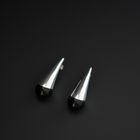 A pair of modern geometric stud earrings with polished silver spike tops and smooth black spherical bases, displayed on a dark black background.