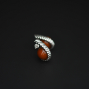 A pair of silver  twisted rope-style earrings with smooth round amber stone, photographed on a dark black background.