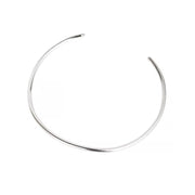 A thin, polished silver-toned metal cuff necklace with an open end, displayed on a clean white background.