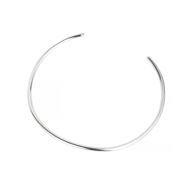 A thin, polished silver-toned metal cuff necklace with an open end, displayed on a clean white background.