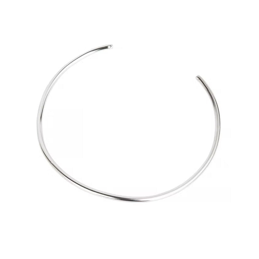 A thin, polished silver-toned metal cuff necklace with an open end, displayed on a clean white background.