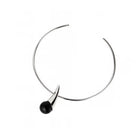A minimalist silver necklace with a single black spherical amber hanging from the front, set against a plain white background.