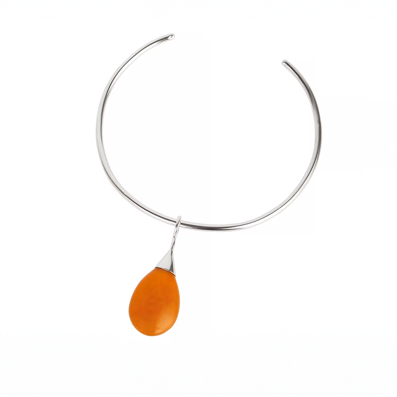 A silver open cuff necklace featuring a teardrop-shaped orange amber pendant, shown against a plain white background.