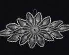 A white crocheted lace doily with a detailed floral pattern, displayed flat against a solid black background.