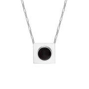 A silver square pendant necklace with a circular black amber, suspended from a silver paperclip chain against a plain white background.