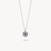 Sterling silver chain necklace featuring a round, textured disc pendant with a small blue sapphire set in the center.