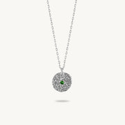 Sterling silver chain necklace featuring a round, textured disc pendant with a small emerald set in the center.