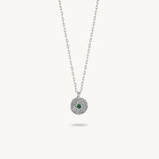 Sterling silver chain necklace featuring a round, textured disc pendant with a small emerald set in the center.