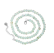 A beaded necklace made of pale mint green prehnite beads with small silver spacer beads and a silver lobster clasp, displayed on a clean white background.