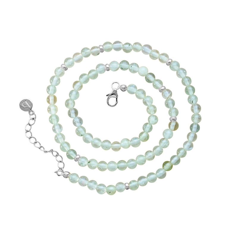 A beaded necklace made of pale mint green prehnite beads with small silver spacer beads and a silver lobster clasp, displayed on a clean white background.