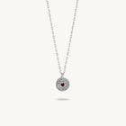 Sterling silver chain necklace featuring a round, textured disc pendant with a small red sapphire set in the center.