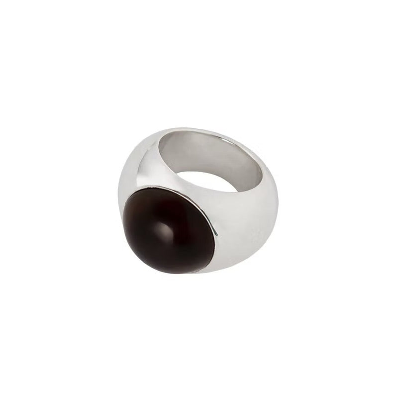 A silver signet ring featuring a smooth, polished dark brown oval amber, shown on a plain white background.