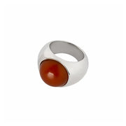 A modern dome-shaped ring featuring a smooth, polished silver band and a large, round amber stone in a warm reddish-brown hue, set against a plain white background.