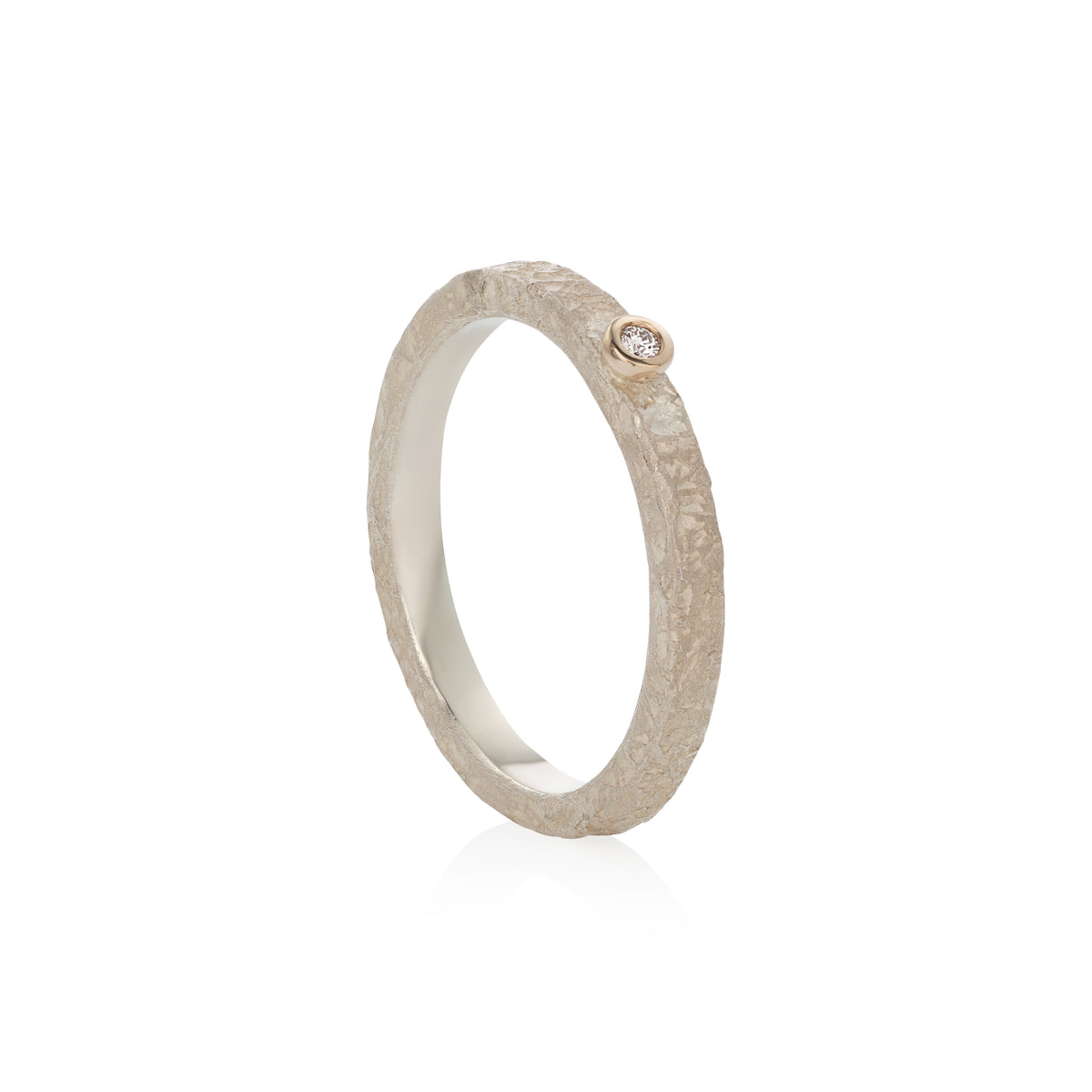 A textured silver band ring with a small round gold accent and a diamond, shown on a clean white background.