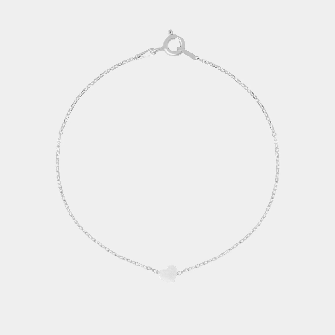 Silver bracelet with heart-shaped pendant on a light gray background