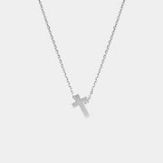 Silver cross necklace on a light gray background