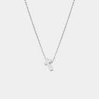 Silver cross necklace on a light gray background
