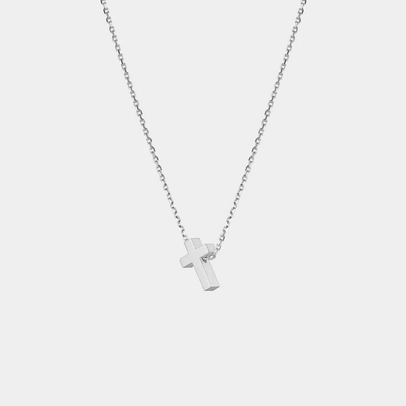 Silver cross necklace on a light gray background