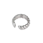 A silver-toned ear cuff ring with a textured, ribbed exterior and a smooth interior, shown on a plain white background.