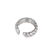 A silver-toned ear cuff ring with a textured, ribbed exterior and a smooth interior, shown on a plain white background.
