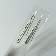 Pair of silver earrings on a clear plastic card with a light gray background