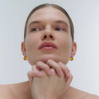 Silver earrings, featuring a structured band and a bold amber element.