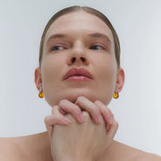 Silver earrings, featuring a structured band and a bold amber element.