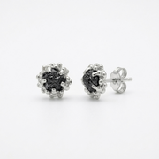 Pair of silver earrings with black diamonds on a white background