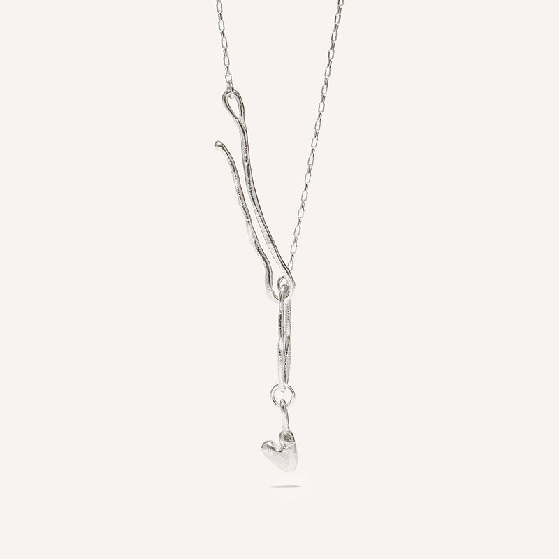 A silver necklace with a heart-shaped pendant and an organic hook fastening.