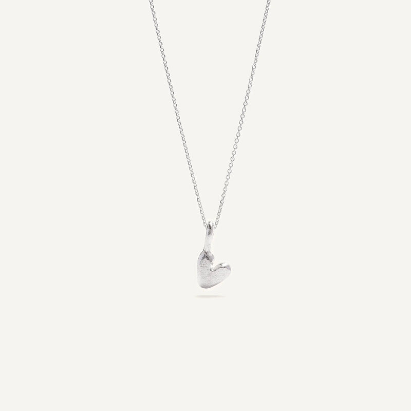 A heart-shaped silver necklace with a pendant on a chain, displayed against a white background.