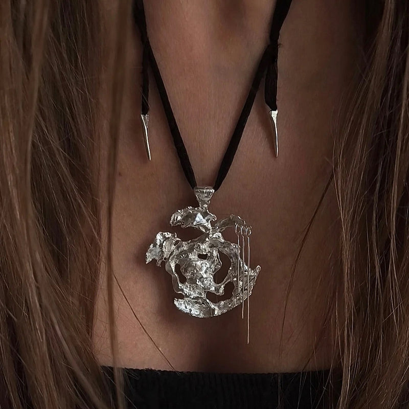 One-of-a-kind necklace featuring a unique water-cast sterling silver pendant with an organic, sculptural form and delicate linear drops. 