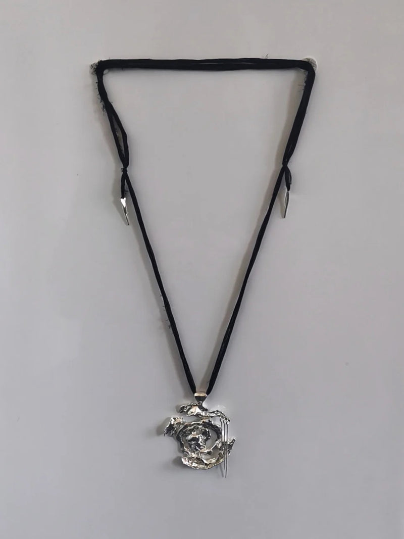 One-of-a-kind necklace featuring a unique water-cast sterling silver pendant with an organic, sculptural form and delicate linear drops. 