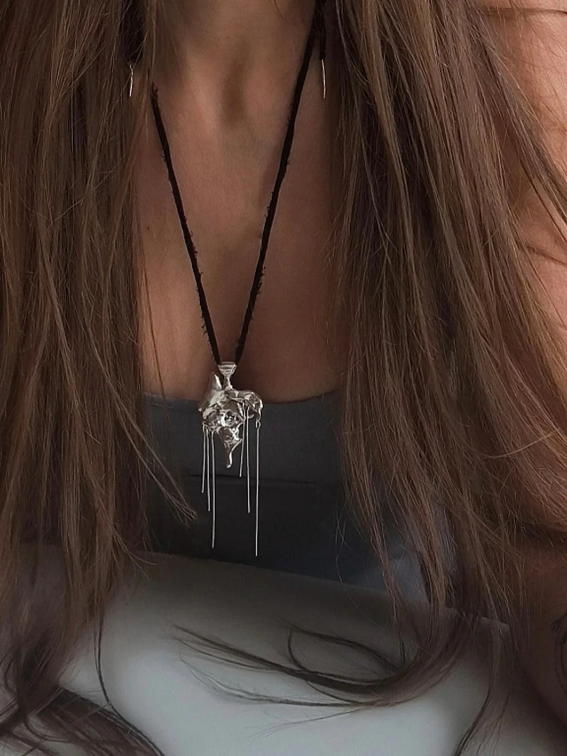 One-of-a-kind necklace featuring a unique water-cast sterling silver pendant with an organic, sculptural form and delicate linear drops.