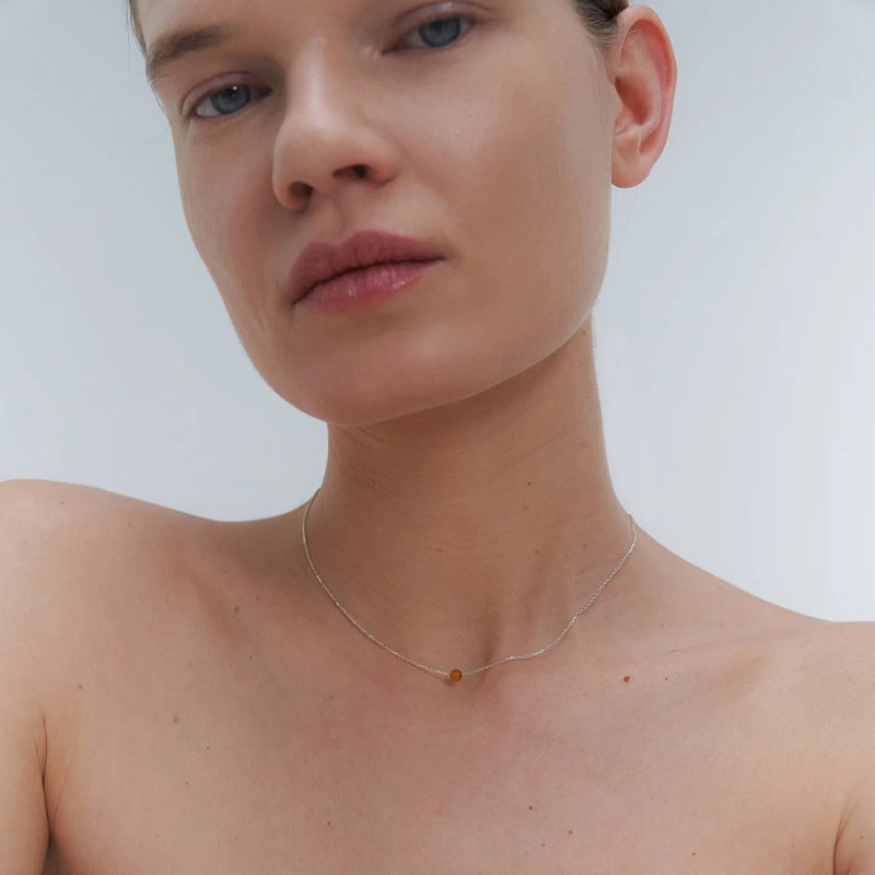 Silver necklace with small Baltic amber pendant by Adele Notes. 