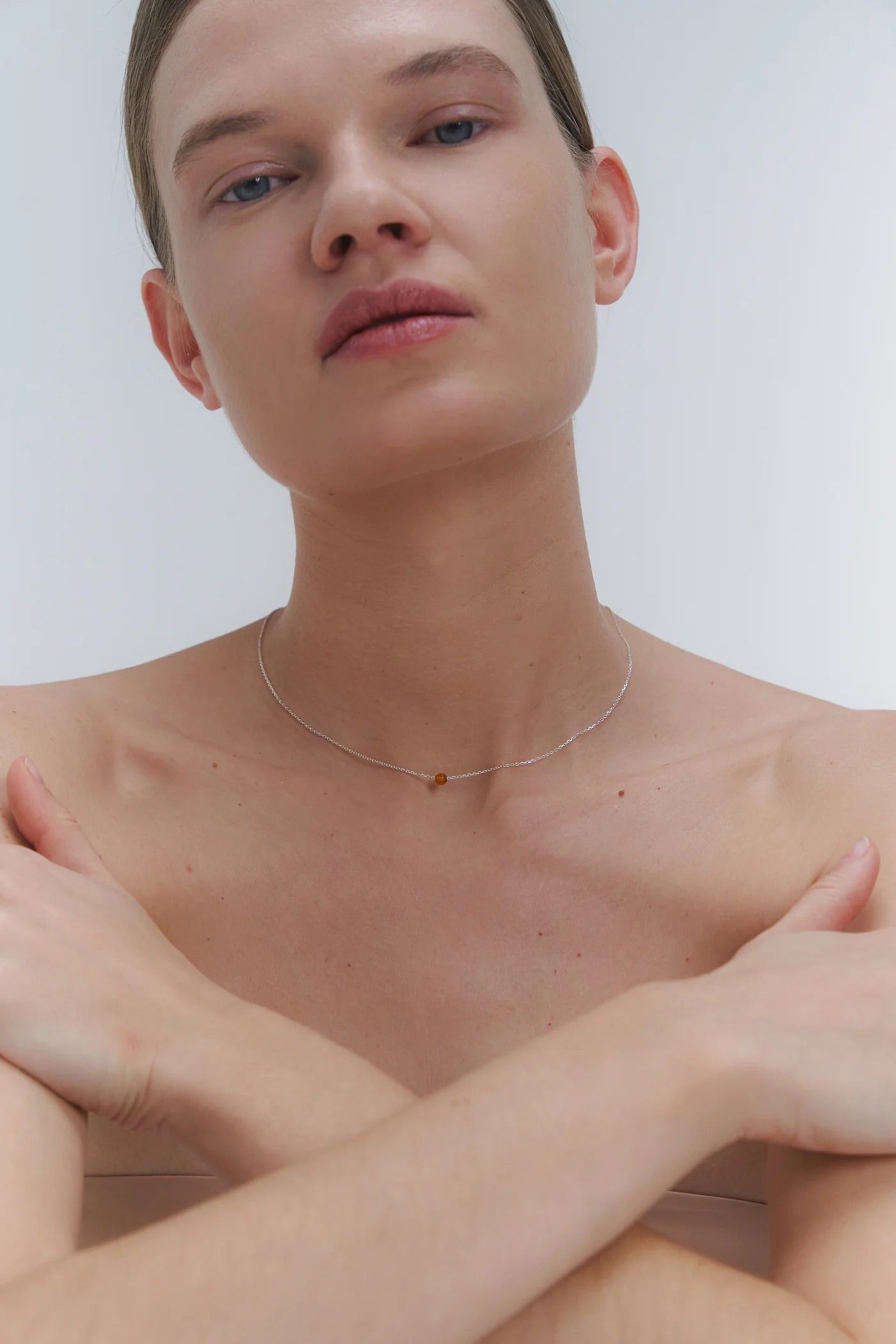 Silver necklace with small Baltic amber pendant by Adele Notes. 